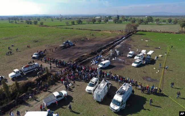 Forensic experts work the area of a pipeline explosion in Tlahuelilpan, Hidalgo state, Mexico, Jan. 19, 2019. A massive fireball that engulfed people scooping up fuel spilling from a pipeline ruptured by thieves killed dozens of people and badly burned ma
