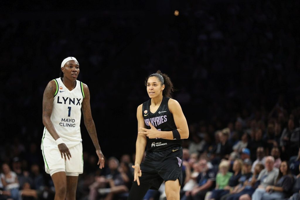 A women's basketball game in progress in a packed arena